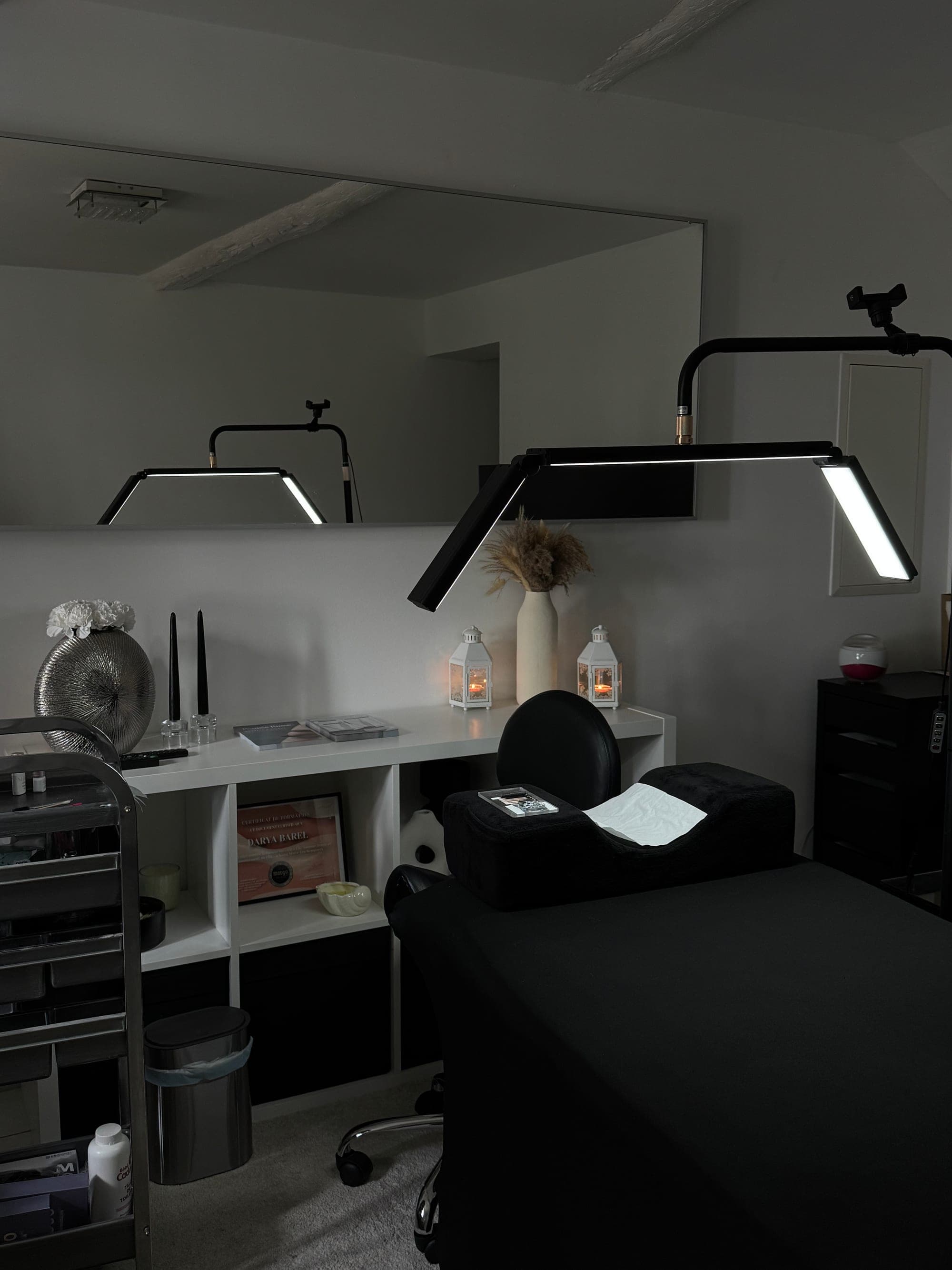La cabine du studio Poupée Russe à Velaux : lit de soin noir et lampe LED
